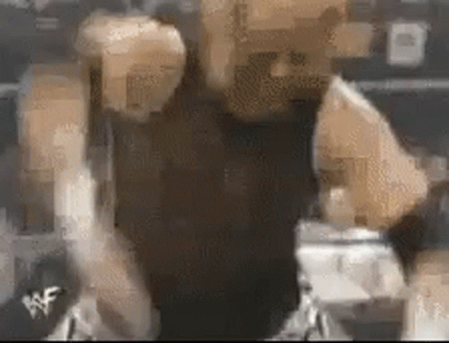 A Blurry Picture Of A Person 'S Face With A Wrestling Logo On The Bottom Right Corner . GIF