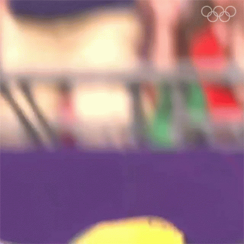 A Blurry Picture Of A Person 'S Face With The Olympic Rings In The Background GIF