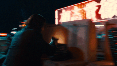 a blurry picture of a person sitting in front of a sign that says ' hong kong ' on it