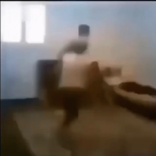 A Blurry Picture Of A Person Sitting On A Couch In A Room . GIF