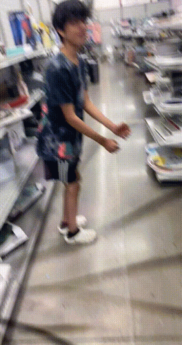 A Blurry Picture Of A Person Standing In A Store Looking At Something GIF