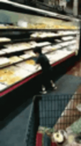 A Blurry Picture Of A Person Standing In Front Of A Display Of Food In A Grocery Store . GIF