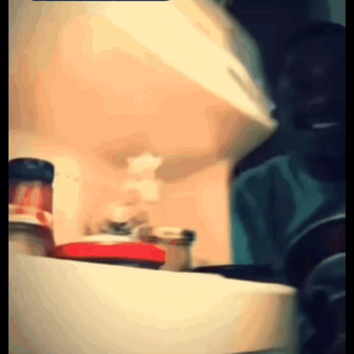 A Blurry Picture Of A Person Standing In Front Of A Refrigerator GIF