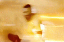 A Blurry Picture Of A Person Standing In Front Of A Wall With A Light Coming Out Of It . GIF