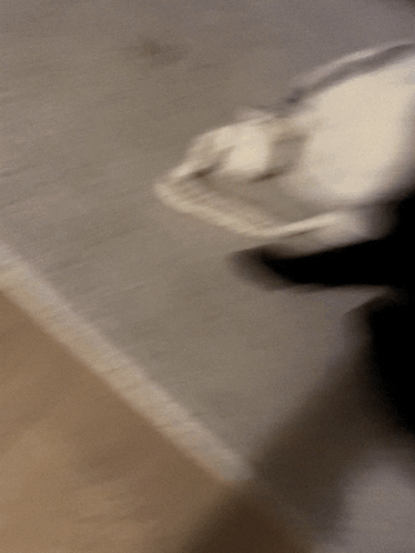 A Blurry Picture Of A Person Standing On A Concrete Floor GIF