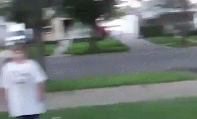 A Blurry Picture Of A Person Walking Down A Sidewalk In Front Of A House . GIF