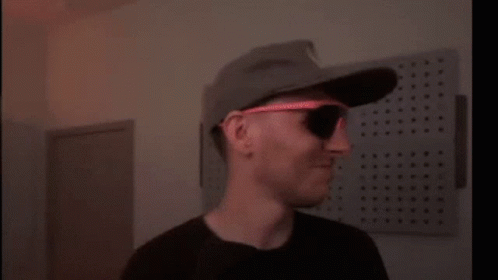 A Blurry Picture Of A Person Wearing A Hat And Sunglasses . GIF