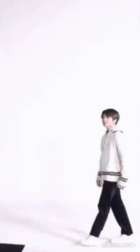 A Blurry Picture Of A Person Wearing A White Jacket And Holding A Purse . GIF