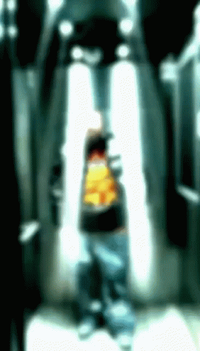 A Blurry Picture Of A Person With A Yellow Shirt GIF