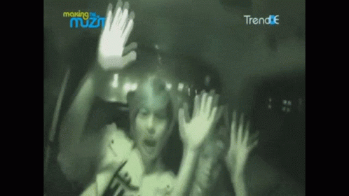 A Blurry Picture Of A Person With Their Hands Up In Front Of A Sign That Says Making The Most GIF