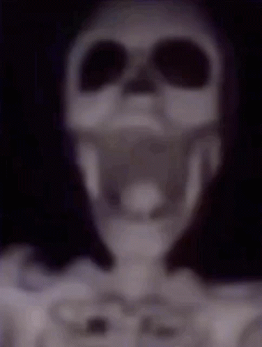 A Blurry Picture Of A Skeleton Wearing Headphones And Sunglasses . GIF