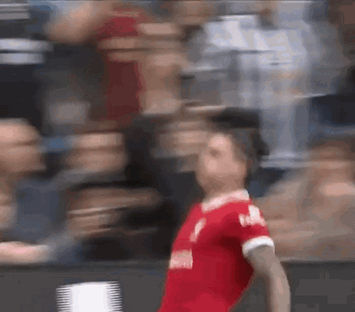A Blurry Picture Of A Soccer Player In A Red Jersey GIF