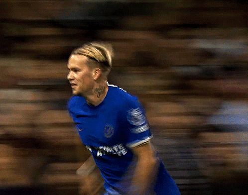 A Blurry Picture Of A Soccer Player Wearing A Blue Jersey That Says ' Premier League ' On The Sleeve GIF