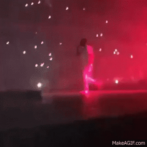 A Blurry Picture Of A Stage With Red Lights Coming Out Of The Ceiling GIF