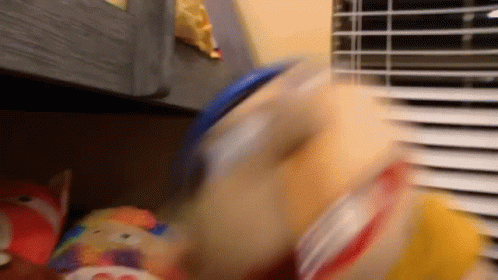 A Blurry Picture Of A Stuffed Animal Being Thrown Into A Container GIF