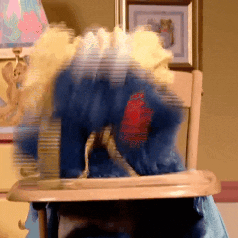 A Blurry Picture Of A Stuffed Animal In A High Chair With A Red Heart On Its Chest GIF