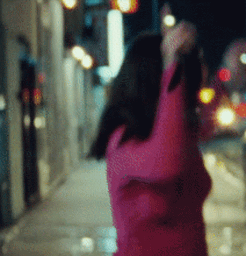 A Blurry Picture Of A Woman In A Pink Sweater GIF