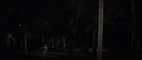 A Blurry Picture Of A Woman 'S Back In The Dark GIF