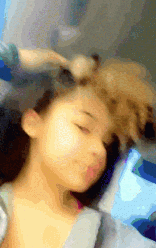 A Blurry Picture Of A Woman Sleeping With Her Eyes Closed And A Dog Laying On Her Head GIF