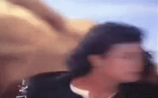 A Blurry Picture Of A Woman Standing In Front Of A Wall . GIF