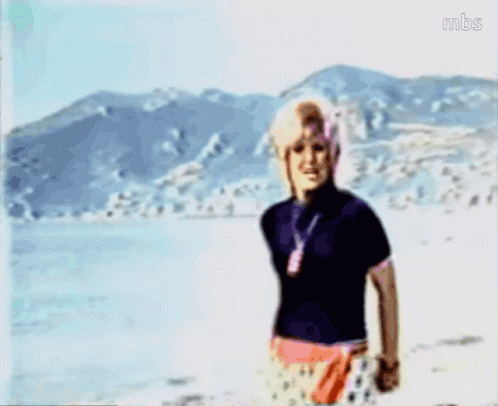 A Blurry Picture Of A Woman Standing On A Beach With Mbs Written On The Bottom Right GIF