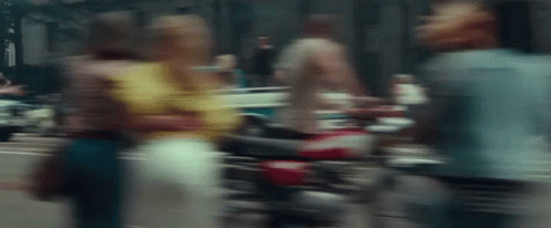 A Blurry Picture Of A Woman Walking Down A Street GIF
