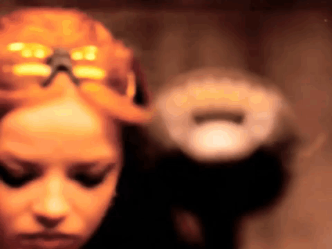 A Blurry Picture Of A Woman With A Pumpkin In Her Hair GIF