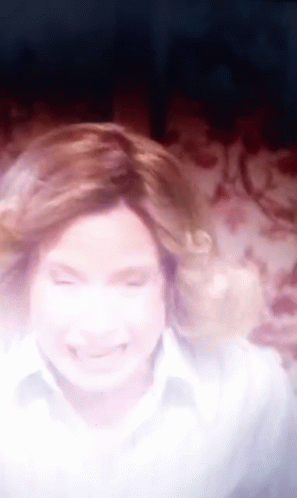 A Blurry Picture Of A Woman With Her Eyes Closed And Her Hair Blowing In The Wind GIF