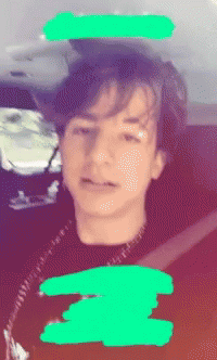 A Blurry Picture Of A Young Boy With A Green Circle Around His Head GIF
