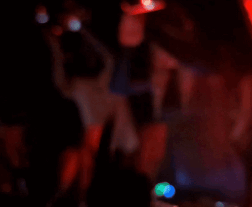 A Blurry Picture Of People Dancing In A Dark Room With A Sign On The Wall That Says ' I Love You ' GIF