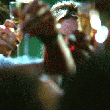 A Blurry Picture Of People Holding Glasses Of Champagne GIF
