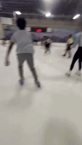 A Blurry Picture Of People Ice Skating In A Rink GIF