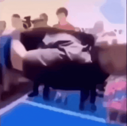 A Blurry Picture Of People Sitting On A Couch In A Room GIF