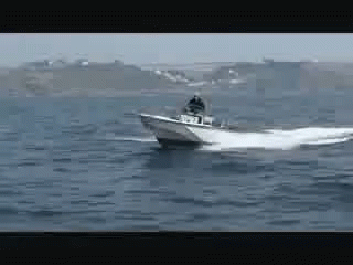 A Boat Is Floating On Top Of A Large Body Of Water GIF