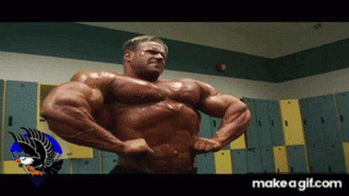 A Bodybuilder Flexes His Muscles In A Locker Room With A Make A Gif.com Logo In The Corner GIF