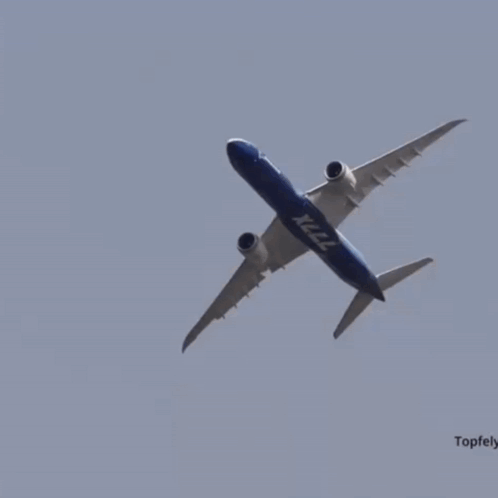 A Boeing X222 Plane Is Flying Through A Clear Blue Sky GIF