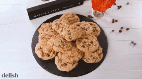 A Book Called Magnolia Table Sits On A Table Next To A Plate Of Cookies GIF