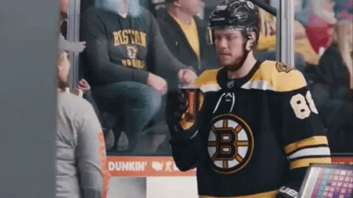 A Boston Bruins Hockey Player Is Drinking A Beer In The Stands GIF