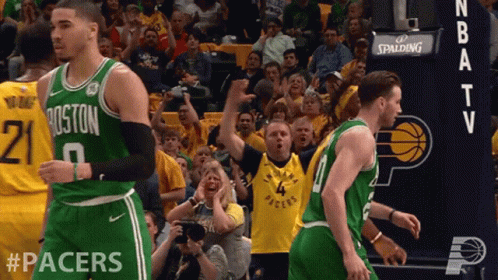 A Boston Celtics Basketball Player Stands In Front Of A Crowd Of Fans GIF