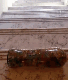 a bottle is sitting on a marble floor in front of stairs