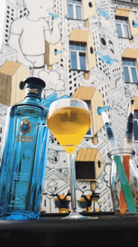 A Bottle Of Bombay Gin Sits Next To A Full Glass GIF