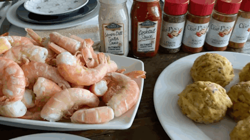 A Bottle Of Cocktail Sauce Sits On A Table Next To A Pile Of Shrimp GIF