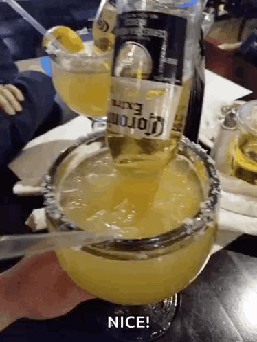 A Bottle Of Corona Is Poured Into A Margarita Glass GIF