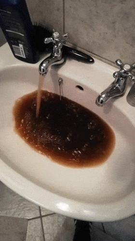 A Bottle Of Dove Shampoo Sits On A Counter Next To A Sink GIF