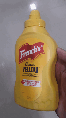 A Bottle Of French 'S Classic Yellow Mustard In A Hand GIF