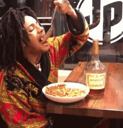 A Bottle Of Hennessy Sits Next To A Plate Of Food GIF