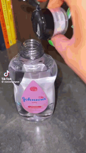 A Bottle Of Johnson 'S Baby Oil Is Being Poured Into Another Bottle GIF