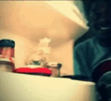 A Bottle Of Ketchup Sits On A Shelf In A Kitchen .. GIF