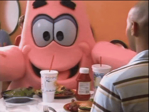 A Bottle Of Ketchup Sits On A Table Next To A Man In A Blue Shirt GIF