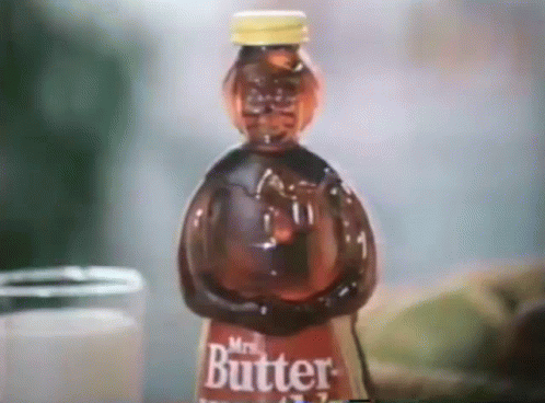 a bottle of mr. butter sits on a table next to a jar